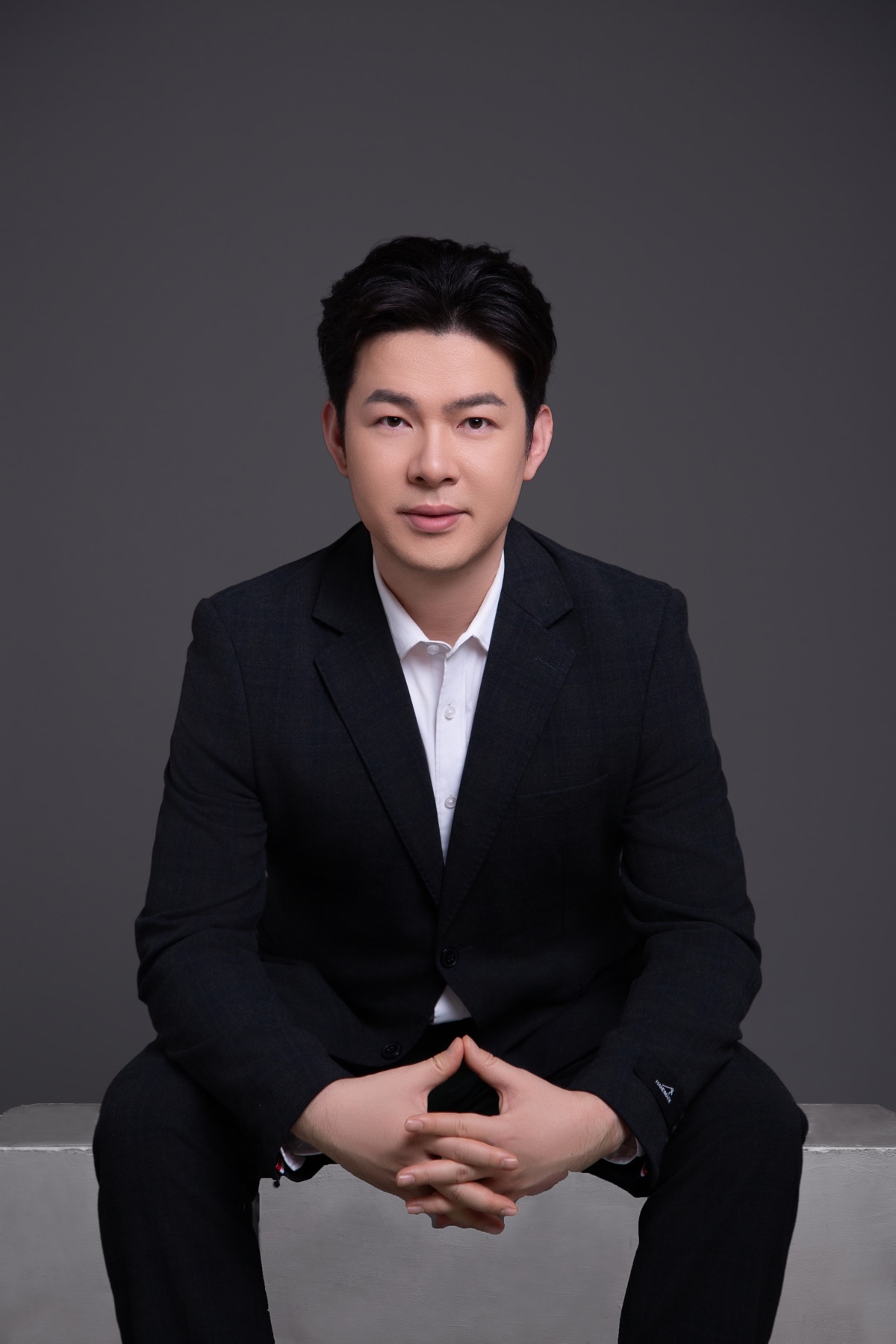 李哈利正面坐姿，雙手自然交握